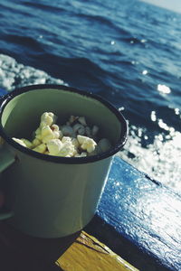 Close-up of drink in cup on table against sea