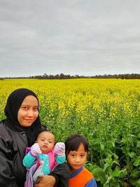 Portrait of woman with children against flowering plants