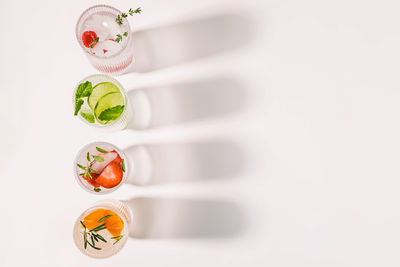 Infused waters with different flavors, summer refreshing drinks in a ribbed glasses, copy space