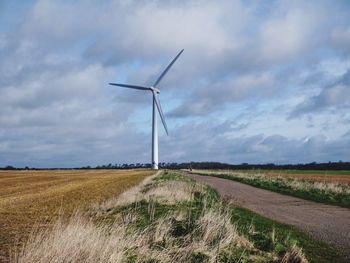 Windmill on field against sky