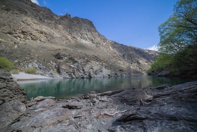 Scenic view of lake and mountains against clear sky