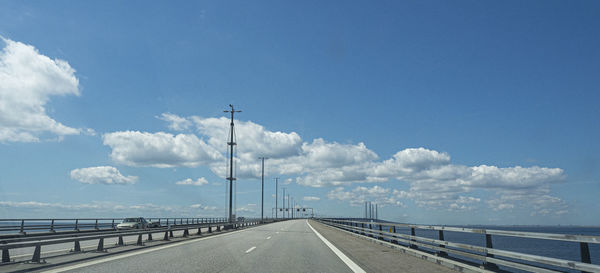 Road leading towards highway against sky