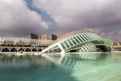 Arch bridge over river against buildings in city