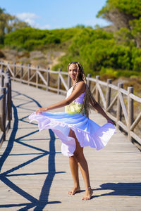 Portrait of woman spinning on wooden bridge