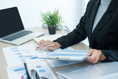 Midsection of man using laptop on table