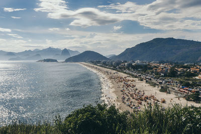 Scenic view of sea and mountains against sky