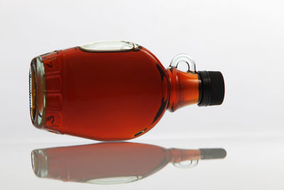 Close-up of oil in bottle against white background