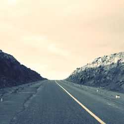 Empty road leading towards mountains