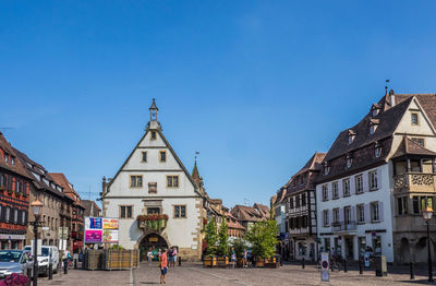 People walking on street against buildings in city