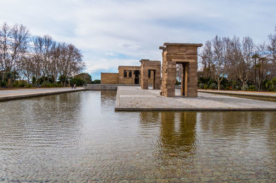 Built structure in lake against sky