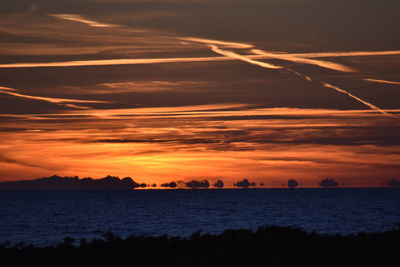 Scenic view of sea against dramatic sky during sunset