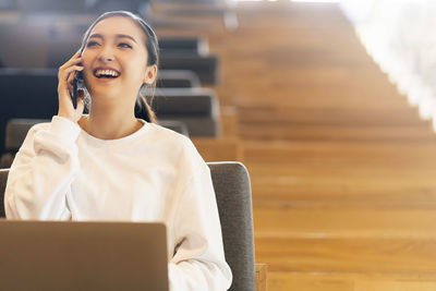 Smiling young woman using mobile phone