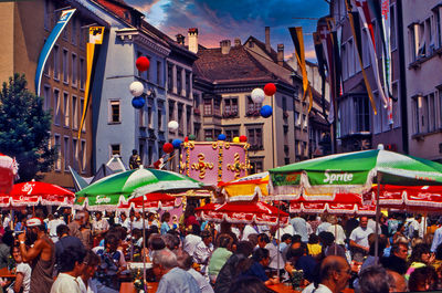 People on street amidst buildings in city