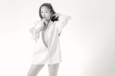 Portrait of woman standing against white background