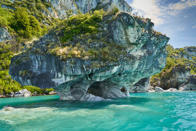 Rock formation in sea against sky