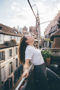 Woman standing in city against sky