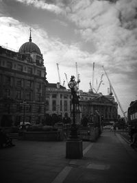 Buildings in city against cloudy sky