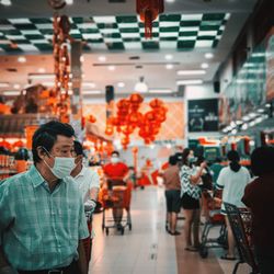 Man wearing mask looking away at shopping shopping mall