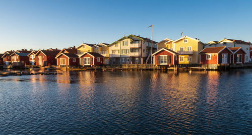 Houses by lake against sky in city