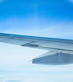 Airplane wing against clear blue sky