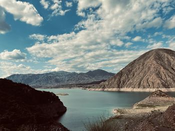 Scenic view of sea and mountains against sky