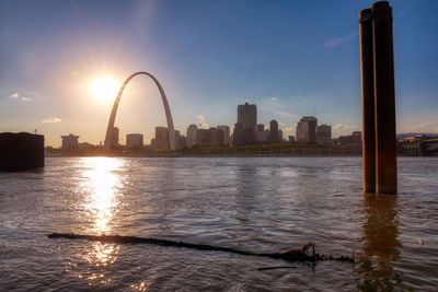 View of buildings by river during sunset