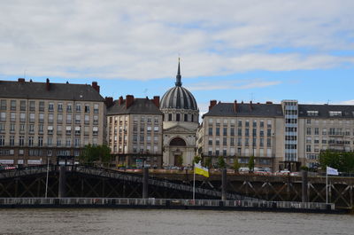 Arch bridge over river against buildings in city