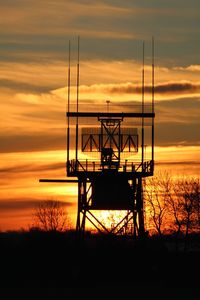 Silhouette tower against sky during sunset