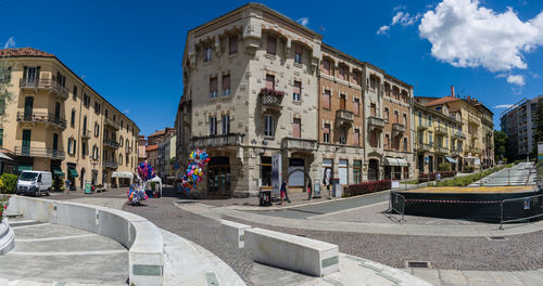 Panoramic view of people in city against blue sky