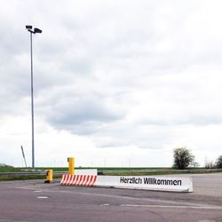 Empty road against cloudy sky