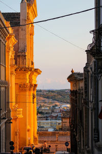 Buildings in city against sky during sunset