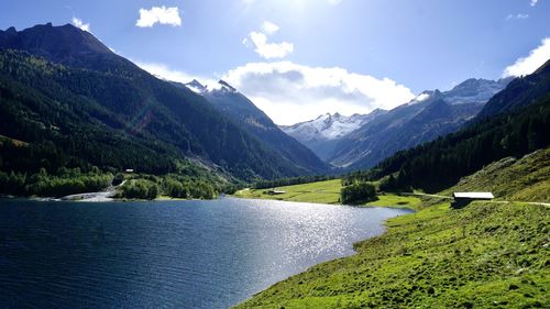 Scenic view of lake by mountains against sky