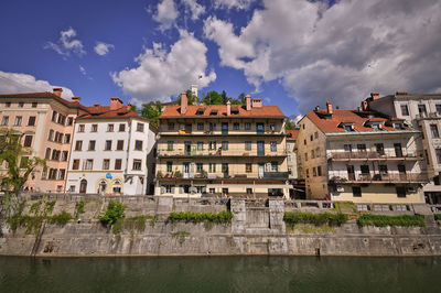 View of buildings in city against cloudy sky