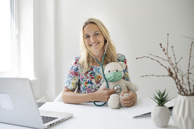 Portrait of smiling woman using laptop at home