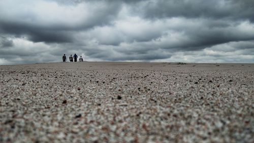 Scenic view of desert against cloudy sky