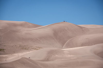 Scenic view of desert against clear blue sky