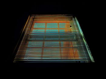 Low angle view of illuminated light bulbs in city at night