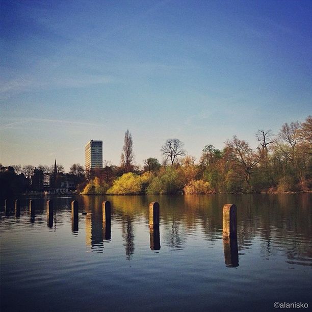 water, waterfront, architecture, building exterior, built structure, reflection, sky, lake, tree, river, blue, rippled, tranquility, tranquil scene, city, nature, outdoors, mid distance, no people, scenics