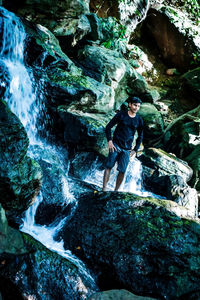 Full length portrait of young man in cave