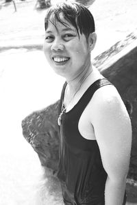 Portrait of woman smiling while standing in sea