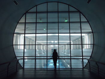 Silhouette woman walking in glass window