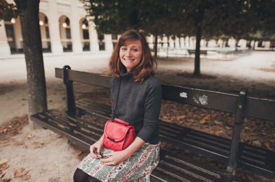 Portrait of young woman sitting on bench