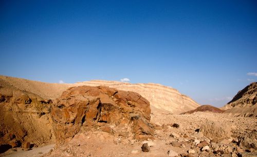 Scenic view of desert against clear blue sky