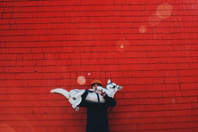 Full length of man standing on red brick wall