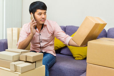 Full length of man sitting on sofa