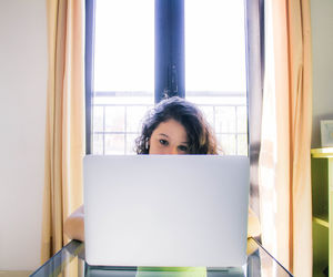 Portrait of woman using laptop at home