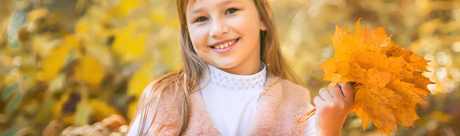 Portrait of smiling girl holding leaves