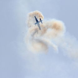 Low angle view of airplane flying against sky