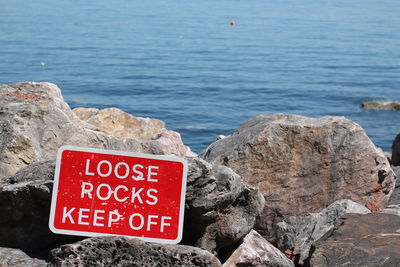 Close-up of text on rock by sea