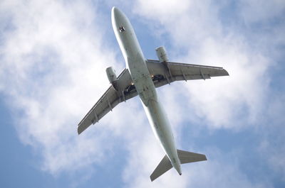 Low angle view of airplane flying against sky